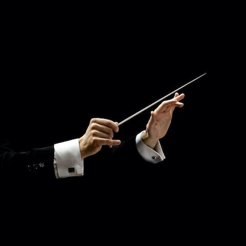 Hands of musical conductor holding a baton