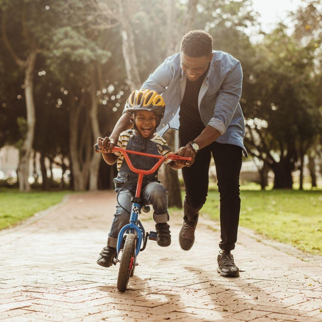 Tall Man Teaching his Son to Ride A Bike